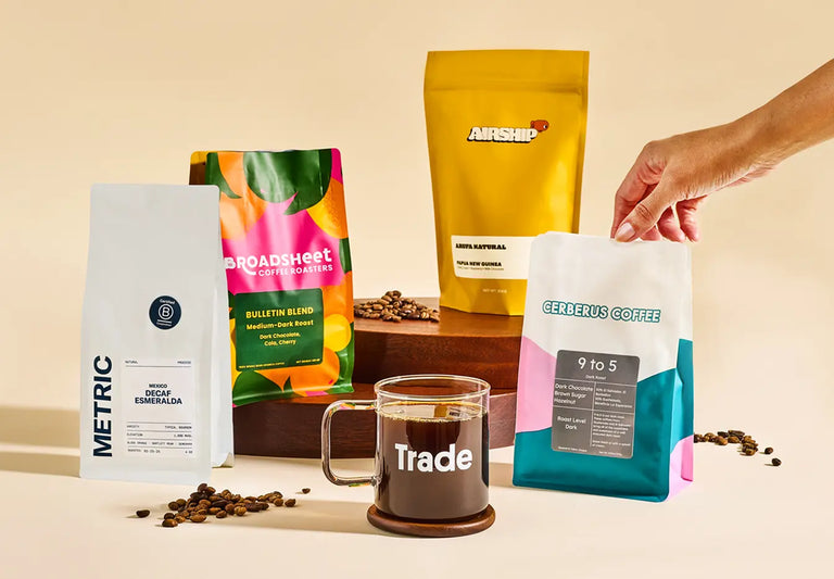 Various coffee bags with different brands and a cup of coffee on a beige background