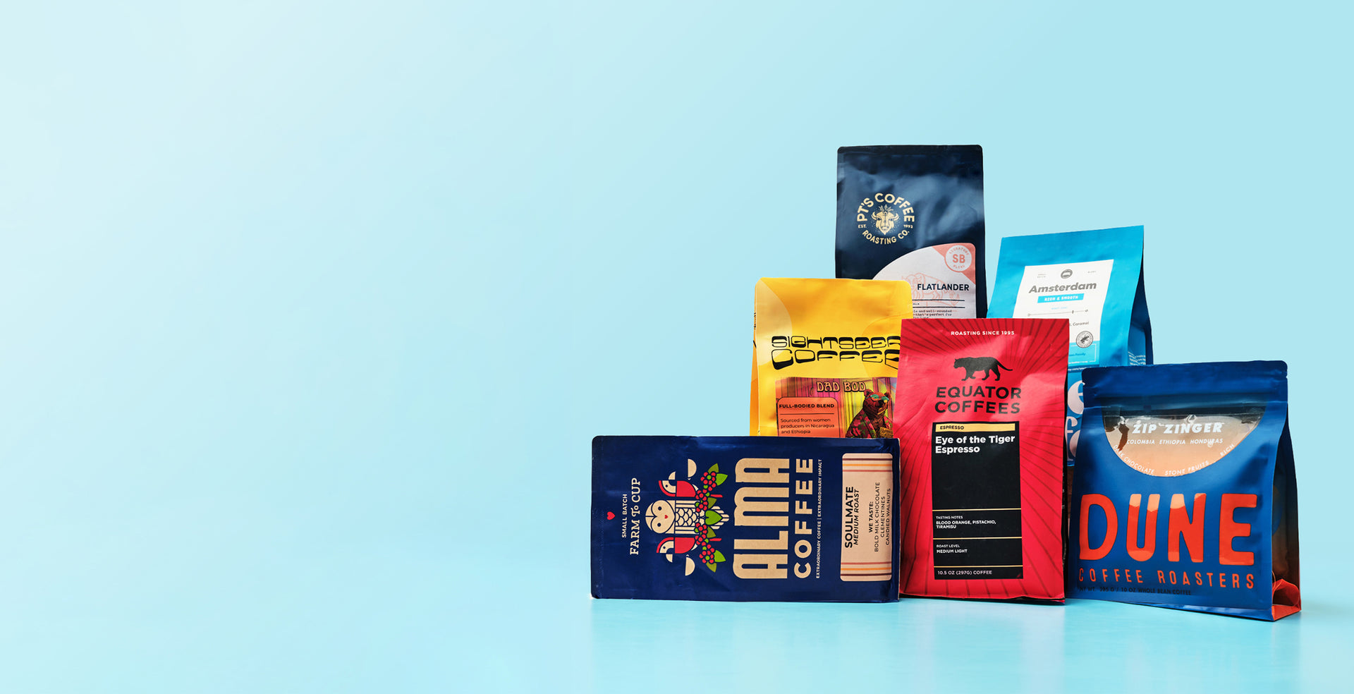 Assorted coffee packages with a cup of coffee on a light blue background