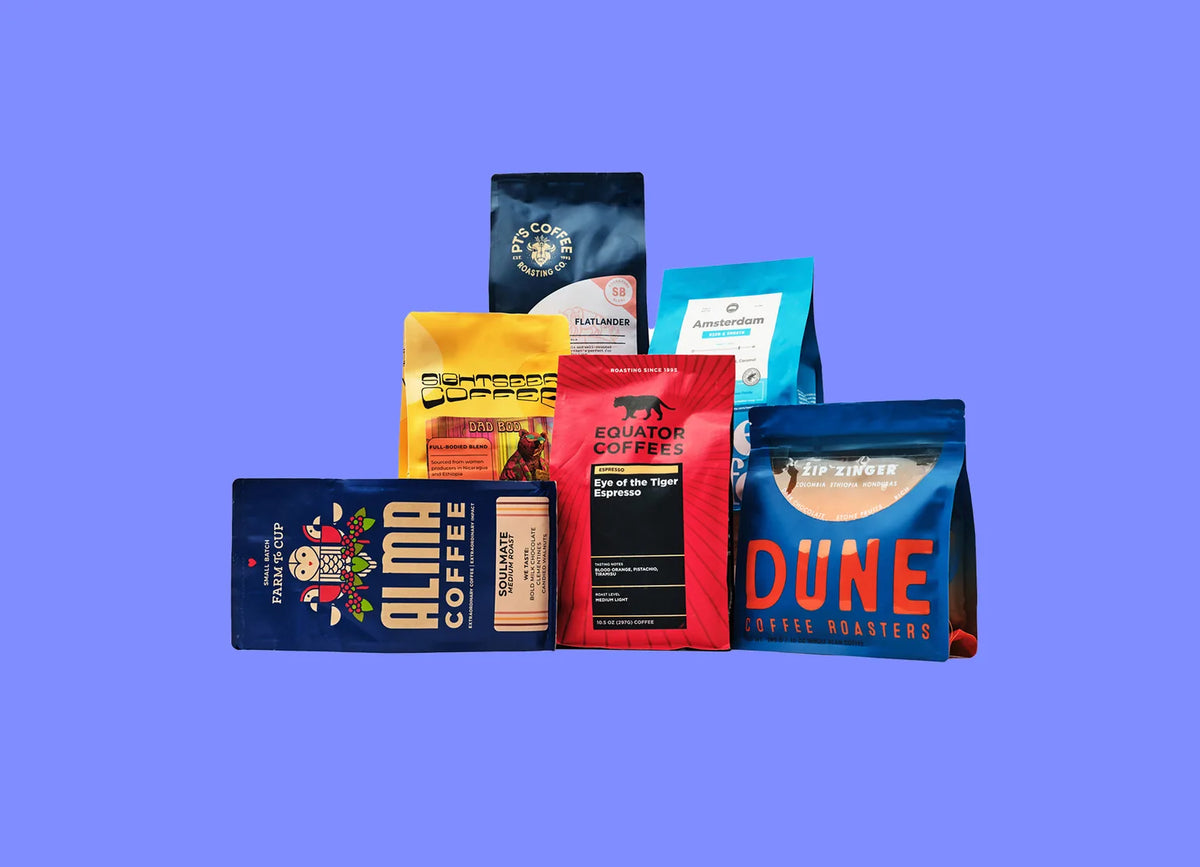 Lineup of coffee bags from Trade roasters on a periwinkle background
